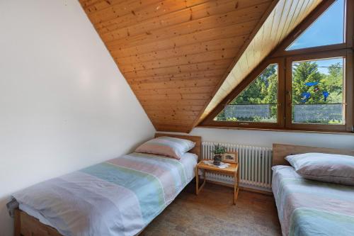 a attic bedroom with two beds and a window at Almschlössle in Gottmadingen