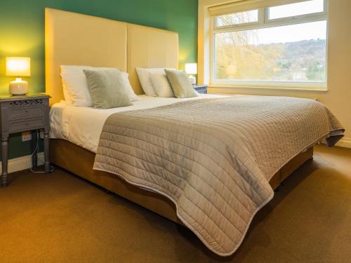 a bedroom with a large bed with a window at Bagshaw Lodge in Bakewell