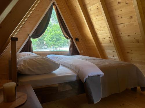 a bed in a room with a window at Gorska Dolina in Ivanova Korita
