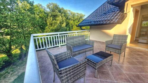 a balcony with chairs and a table on a porch at Villa Nature in Hadžići