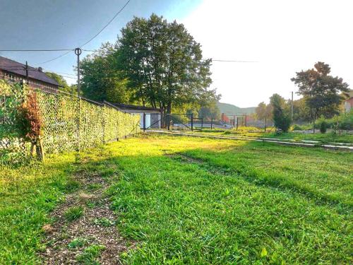 a fence in the grass next to a field at Villa Nature in Hadžići