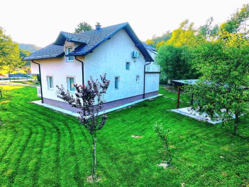 a large house in a yard with trees at Villa Nature in Hadžići
