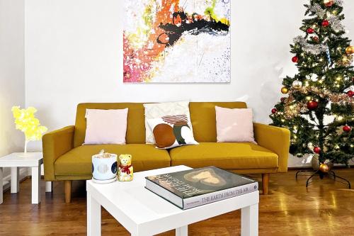 a living room with a yellow couch and a christmas tree at Amazing Location with Parking in Kent