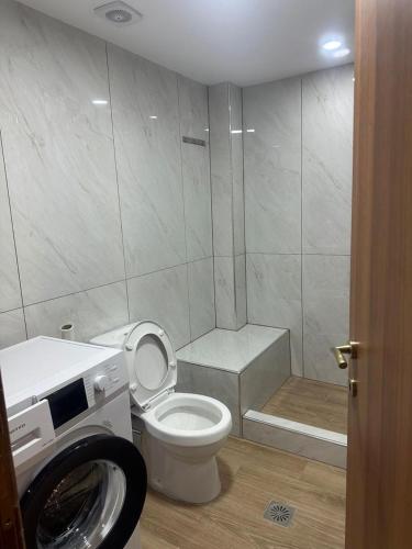 a bathroom with a toilet and a washing machine at Advance Real Estate OE in Alexandroupoli