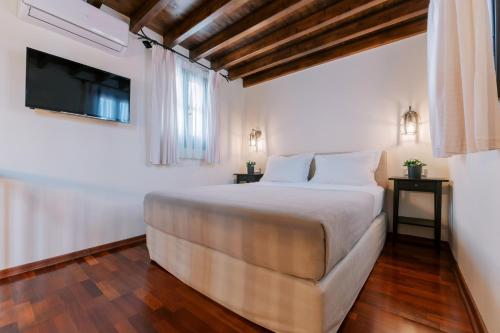 a bedroom with a large bed and a television at Zacosta Villa Hotel in Rhodes Town
