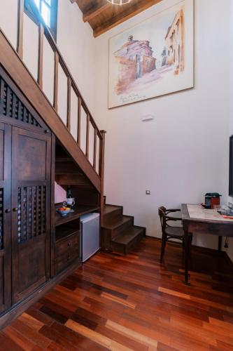 a living room with a staircase and a table at Zacosta Villa Hotel in Rhodes Town