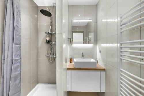 une salle de bain blanche avec un lavabo et une douche dans l'établissement Lovely Place le charme près des commerces, à Lorgues