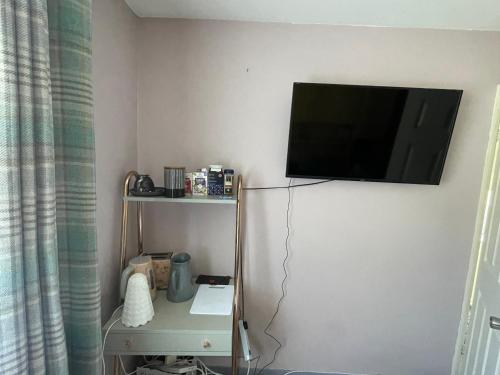 a flat screen tv hanging on a wall in a room at Stay with Anisia in Guestling