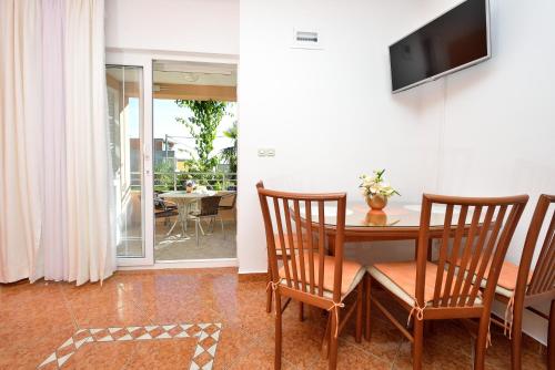 a dining room with a table and chairs and a television at Villa Zdenka in Pakoštane