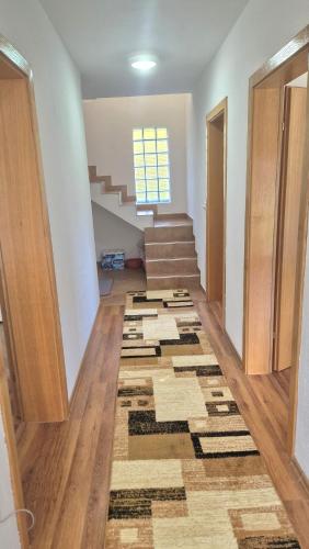 a hallway with stairs and a rug on the floor at Villa Nature in Hadžići