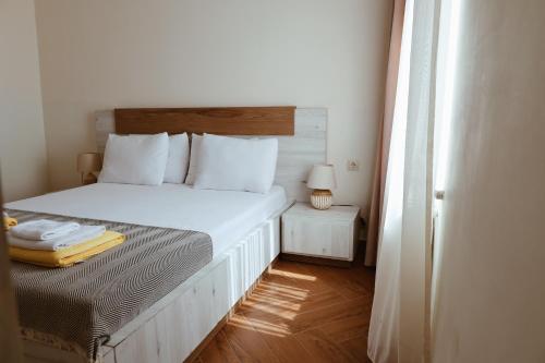 a bedroom with a white bed with a wooden headboard at OXYGEN Shekvetili in Shekvetili