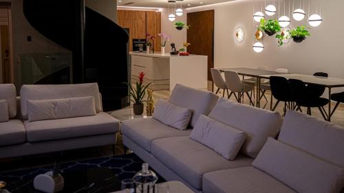 a living room with a couch and a dining room at Enchanted Harmony by AURA in Żurrieq