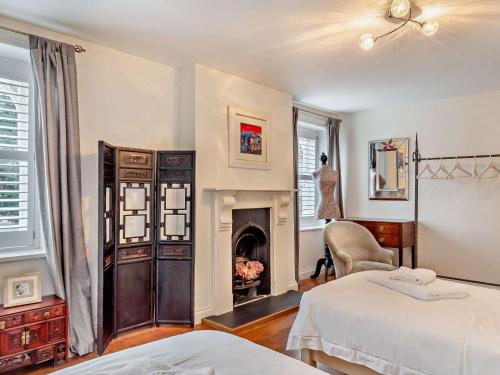 1 dormitorio con 2 camas y chimenea en 2 Bed in Marazion 82154, en Marazion