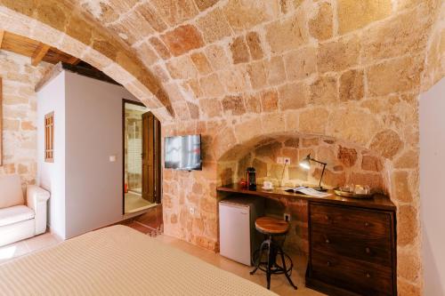 a bedroom with a stone wall at Zacosta Villa Hotel in Rhodes Town