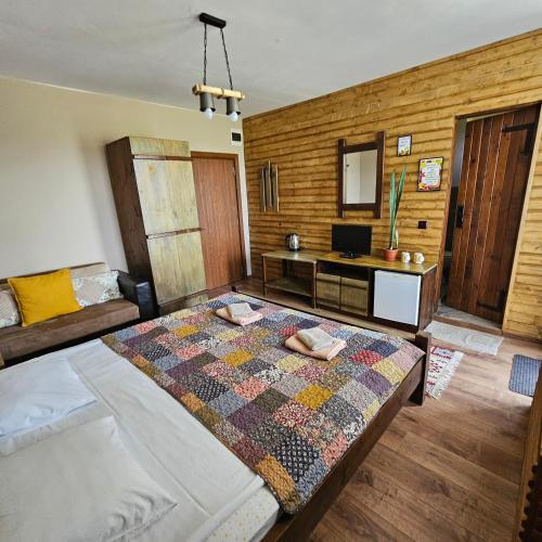 a bedroom with a large bed and a desk at Guest House Belchin View in Belchin
