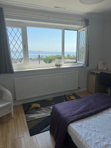 a bedroom with a bed and a large window at Luxury Seaview Escape - Mumbles in Oystermouth