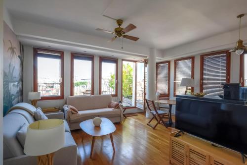 un salon avec un canapé et une télévision à écran plat dans l'établissement Cosy studio with terrace overlooking Marseille, à Marseille