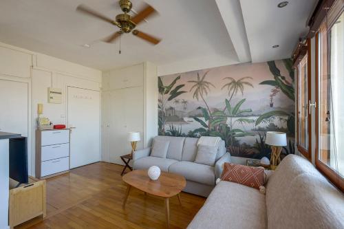 un salon avec un canapé et un ventilateur de plafond dans l'établissement Cosy studio with terrace overlooking Marseille, à Marseille