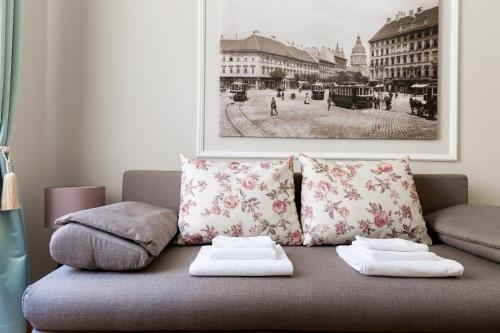 a couch with two pillows on it in a living room at Lisianthus Apartments in Budapest