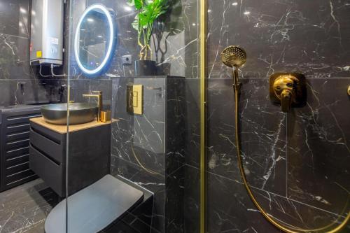 a bathroom with a shower with a sink and a mirror at Cataleya Apartments Makarska in Makarska