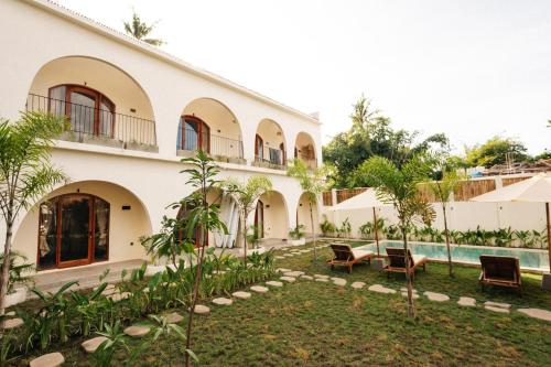an external view of a building with a courtyard at TWINFIN Surf House in Kuta Lombok