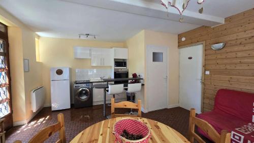 un salon avec une table et une cuisine dans l'établissement Appartements à la Bourboule, à La Bourboule