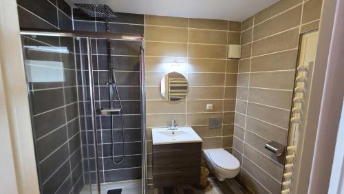 une salle de bain avec toilettes, lavabo et douche dans l'établissement Appartements à la Bourboule, à La Bourboule