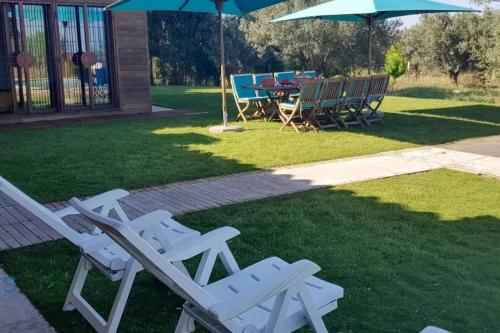 a group of chairs and a table and umbrella at Domaine Essanya Chalet and bungalows Nature quiet and private pool in Dawwār al Frinine