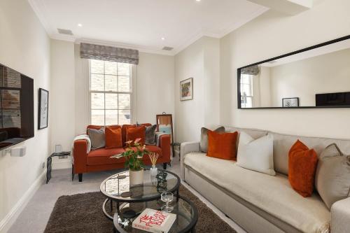 a living room with a couch and a table at Knightsbridge Townhouse Private Terrace & Harrods in London