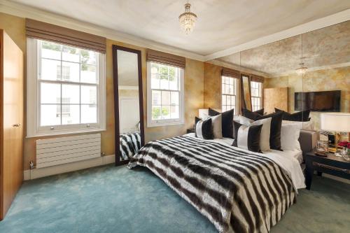 a bedroom with a bed with a black and white comforter at Knightsbridge Townhouse Private Terrace & Harrods in London