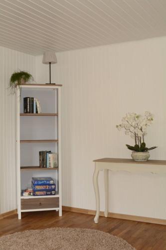 a room with a table and a book shelf at Wellness-Ferienwohnung-EifelErnstbergblick 1 in Daun