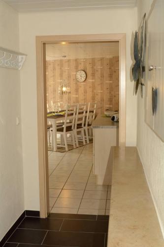 a kitchen and dining room with a clock on the wall at Wellness-Ferienwohnung-EifelErnstbergblick 1 in Daun