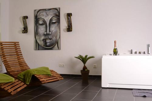 a living room with a table and a mask on the wall at Wellness-Ferienwohnung-EifelErnstbergblick 1 in Daun