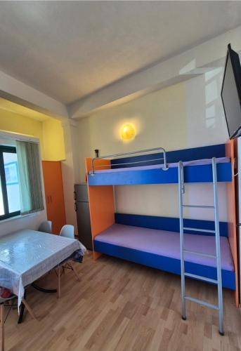 a bedroom with two bunk beds and a television at Apollo - Porat 4 Apartman in Drasnice