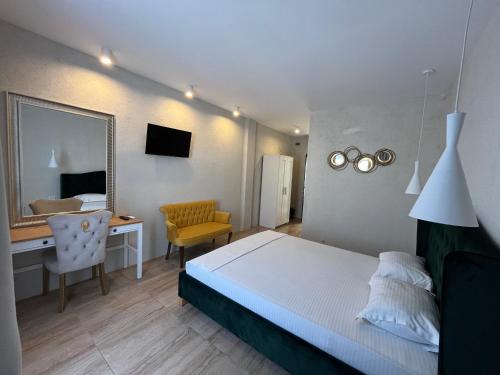 a bedroom with a bed and a desk and a mirror at Villa Gyos in Costinesti