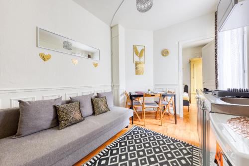 un salon avec un canapé et une table dans l'établissement Le Cocoon Doré, à Clichy