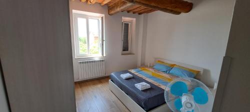 a bedroom with a bed with blue sheets and a window at A casa di Elizabeth in Porcari