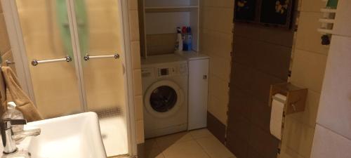 a bathroom with a washing machine and a sink at Apartament Na Wydmie in Ustka