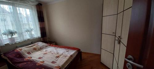 a small bedroom with a bed and a window at Apartament Na Wydmie in Ustka