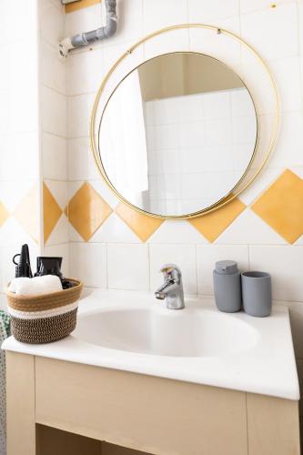 une salle de bain avec un lavabo et un miroir dans l'établissement Le Cocoon Doré, à Clichy