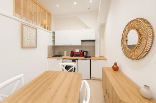 - une cuisine avec une table en bois et un miroir dans l'établissement 2 pieces avec mezzanine et deco design - Paris 9, à Paris