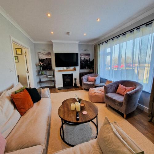 a living room with a couch and a table at Luxury Sea View Retreat with Hot Tub Sleeps 8 in Dover
