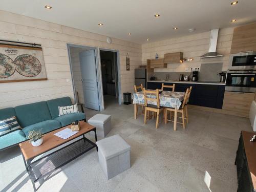 un salon avec un canapé bleu et une table dans l'établissement Kerreizh, à Le Tour-du-Parc