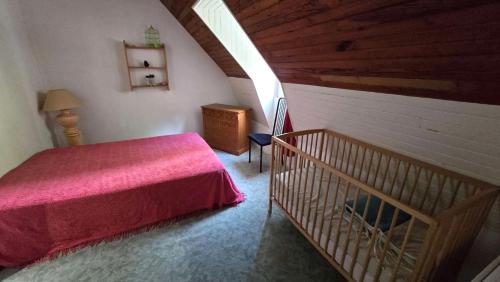 a bedroom with a red bed and a wooden ceiling at Maison 10 personnes Chez Perrine et Nicolas in La Bourboule