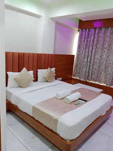 a bedroom with a large bed with two pillows at Hotel Metro AC Room in Vadodara