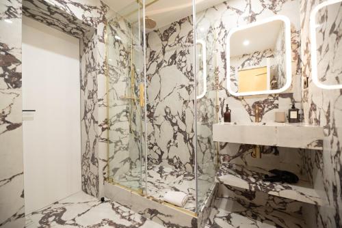 une salle de bain avec une douche, un lavabo et un miroir dans l'établissement Stylish Flat in Paris' Center, à Paris