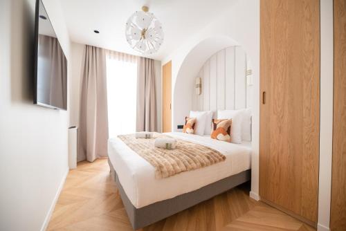 Cette chambre comprend un grand lit et un lustre. dans l'établissement Stylish Flat in Paris' Center, à Paris