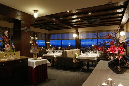 a restaurant with white tables and chairs and flowers at Haus Rebland Urlaubsglück-Hotel in Baden-Baden