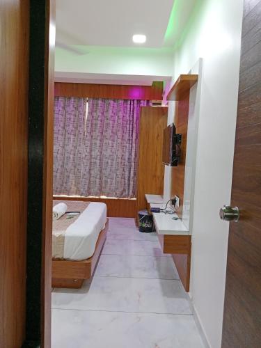 a bedroom with a bed and a sink and a window at Hotel Metro AC Room in Vadodara
