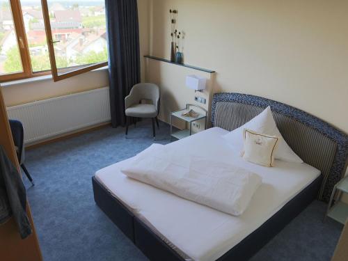 a bedroom with a bed with a pillow on it at Haus Rebland Urlaubsglück-Hotel in Baden-Baden